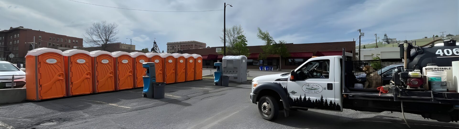 High Country Portable Toilets service truck with a row of clean units staged for delivery in Montana